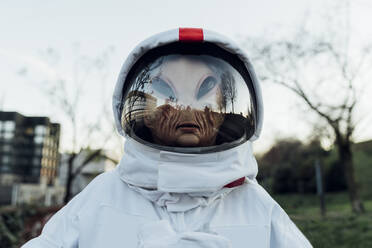 Astronautin mit Alien-Maske im Freien stehend - MEUF02479
