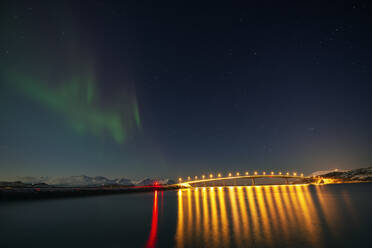 Norwegen, Tromso, Sommaroy, Aurora Borealis über beleuchtete Brücke - RUEF03264