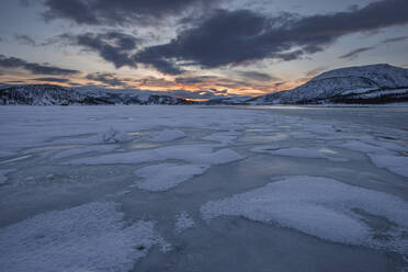 Norway, Tromso, Frozen lake on Senja Island at sunrise - RUEF03277