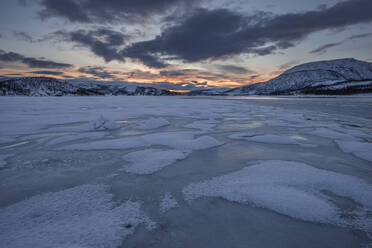 Norwegen, Tromso, Gefrorener See auf der Insel Senja bei Sonnenaufgang - RUEF03277