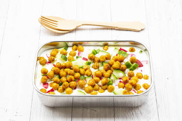 Studio shot of wooden cutlery and lunch box of yogurt with chick-peas, cucumbers and radishes - LVF09149