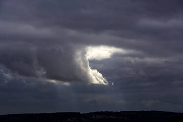 Sunlight piercing through cloudy sky at dusk - NDF01284