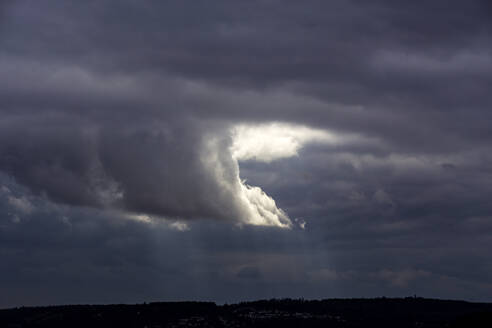 Sonnenlicht durchdringt den bewölkten Himmel in der Abenddämmerung - NDF01284