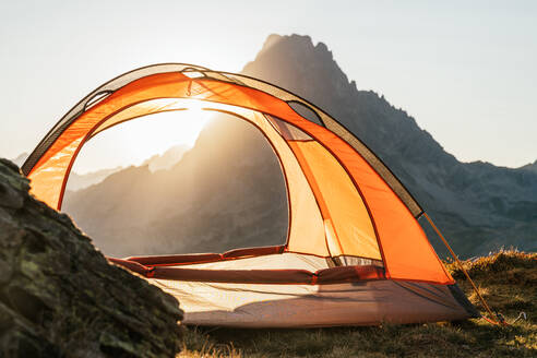 Modernes Campingzelt auf einem Hügel im Hochland vor dem Hintergrund des Sonnenaufgangs in den Pyrenäen - ADSF23196