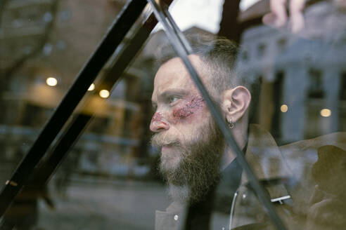 Seitenansicht Hipster Mann mit Bart und Kino Make-up posiert auf der Straße - ADSF23218