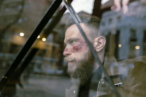 Side view hipster man with beard and cinema makeup posing on the street - ADSF23218