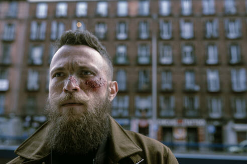 Hipster man with beard and cinema makeup posing on the street - ADSF23219