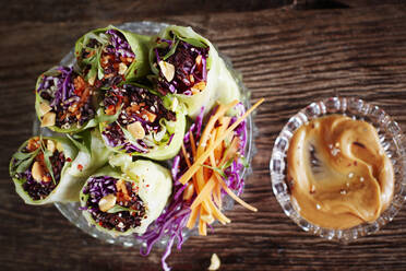 Dipping bowl with peanut butter and cabbage rolls with black rice, sesame seeds, carrot and red cabbage - KSWF02224