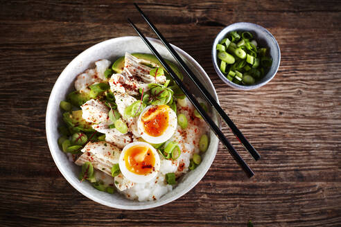 Schüssel Congee mit Hühnerbrust, gekochtem Ei, Avocado, Frühlingszwiebeln und Kräutern - KSWF02225