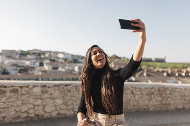 Junger Tourist macht Selfie mit seinem Handy an einem sonnigen Tag - MRRF01032