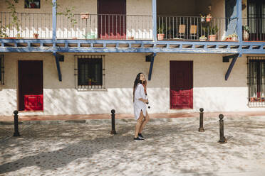 Woman standing on walkway during sunny day - MRRF01081