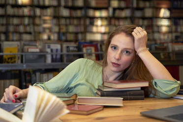 Beautiful woman with books sitting in library - VEGF04375