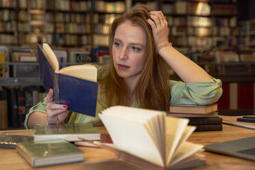 Beautiful woman reading book in library - VEGF04382