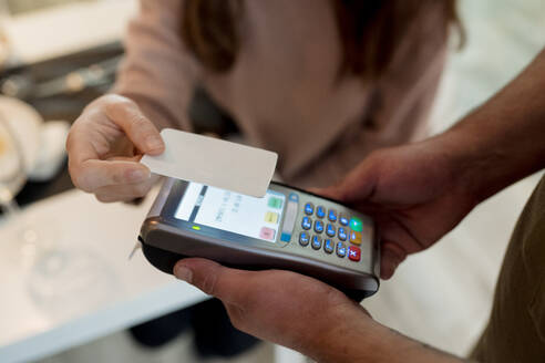 Frau bezahlt mit Kreditkarte im Restaurant - EGAF02356