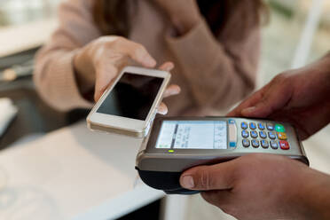 Woman doing contactless payment at restaurant - EGAF02357