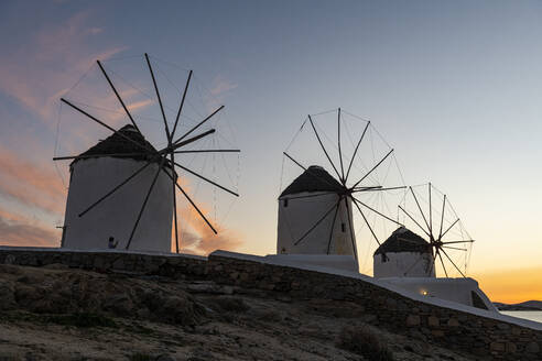 Greece, Mykonos, Horta, Row of windmills at sunset - RUNF04331