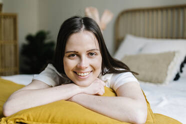 Lächelnde Frau auf dem Bett liegend zu Hause - XLGF01661