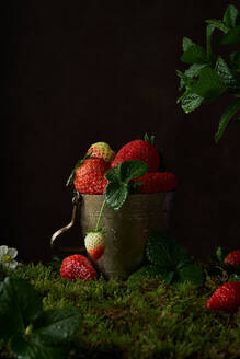 Komposition mit frischen reifen roten Erdbeeren mit Minze Blätter in Metallschale auf dunklem Hintergrund platziert - ADSF23402