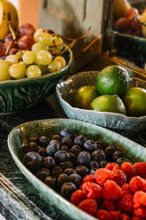 Verschiedene reife Früchte und leckere Beeren in Tellern auf dem Tisch für das Frühstücksbuffet - ADSF23430
