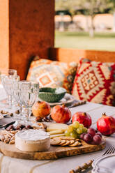 Tisch mit Geschirr und verschiedenen reifen Früchten und köstlichen Vorspeisen auf der Terrasse serviert - ADSF23433