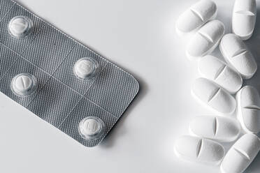 Nahaufnahme von oben Stapel von Pillen und Blister mit weißen Tabletten auf weißem Hintergrund platziert - ADSF23447