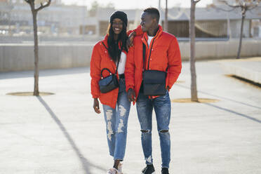 Smiling woman walking with boyfriend at park during sunny day - MPPF01694