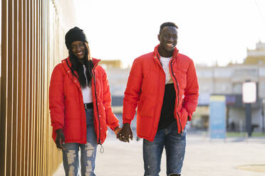 Smiling couple holding hands during sunny day - MPPF01702