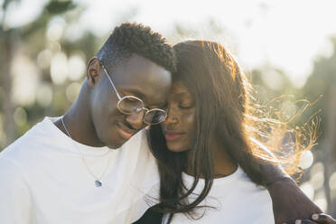 Affectionate couple with eyes closed during sunny day - MPPF01709