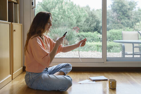 Frau fotografiert Rechnung, während sie zu Hause sitzt - AFVF08695