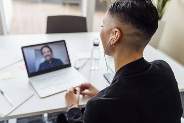 Businesswoman attending meeting through video call on laptop at office - MEUF02534