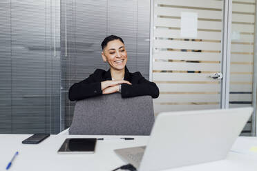 Female professional smiling during video call on laptop at office - MEUF02550