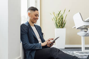 Young entrepreneur using digital tablet while sitting in office - MEUF02599