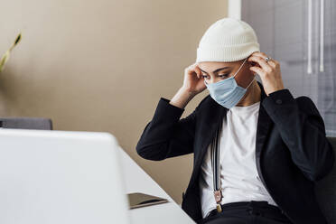 Geschäftsfrau mit Gesichtsschutzmaske im Büro - MEUF02632