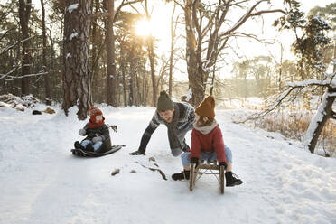Vater spielt mit Söhnen im Winter im Schnee - FVDF00026