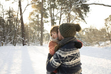 Father kissing son during winter - FVDF00032