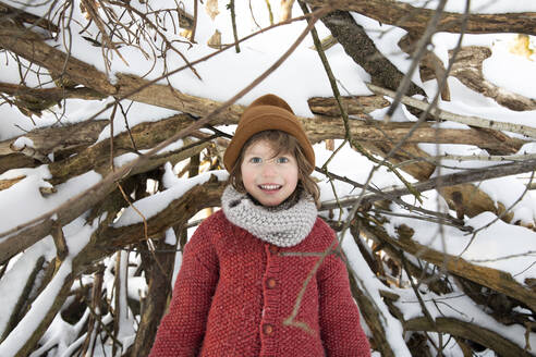 Niedlicher Junge in warmer Kleidung am Waldrand im Winter - FVDF00035