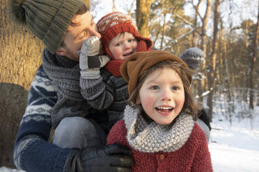 Father holding curious son in warm clothing during winter - FVDF00047