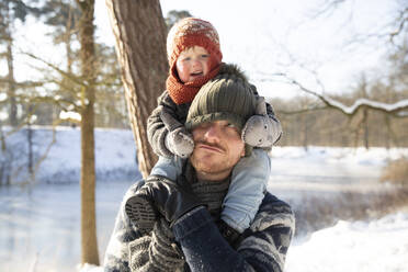 Vater trägt seinen Sohn im Winter auf der Schulter - FVDF00055