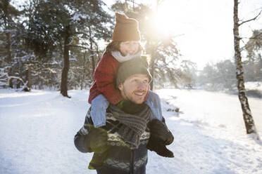 Vater trägt Sohn auf der Schulter im Winter an einem sonnigen Tag - FVDF00063