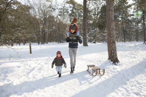 Vater geht im Winter mit seinen Söhnen im Schnee spazieren - FVDF00067