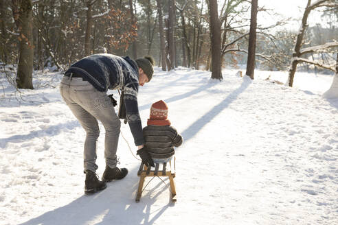 Vater bringt seinem Sohn das Schlittenfahren im Schnee bei - FVDF00070