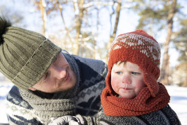 Vater sieht verwirrten Sohn im Winter an - FVDF00076