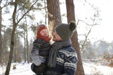 Vater in warmer Kleidung schaut auf weinenden Sohn im Winter - FVDF00082