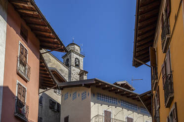 Glockenturm der Kirche San Giorgio in der Nähe von Häusern in Bagolino, Provinz Brescia, Lombardei, Italien - MAMF01742