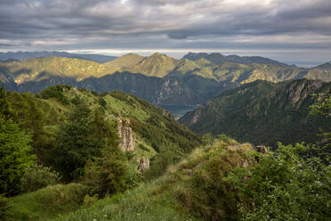 Sunlight over mountains at Lake Idro and lake Garda near valley in Province of Brescia, Lombardy, Italy - MAMF01757