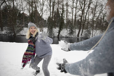 Älteres Paar spielt im Winter mit Schnee - FVDF00109