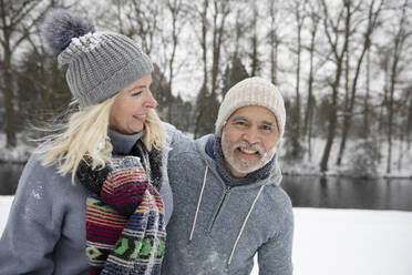 Cheerful senior couple playing outdoors during winter - FVDF00114