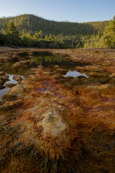 Amazing view of river with clear water and orange bottom on sunny day in Minas de Rio tinto with mountain landscape on the background - ADSF23496