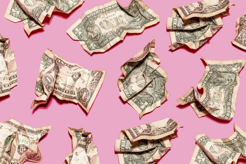 Pattern of crumpled one dollar bills lying against pink background - GEMF04762