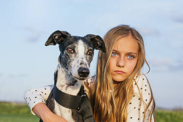 Blond girl with greyhound looking away - JCMF01952